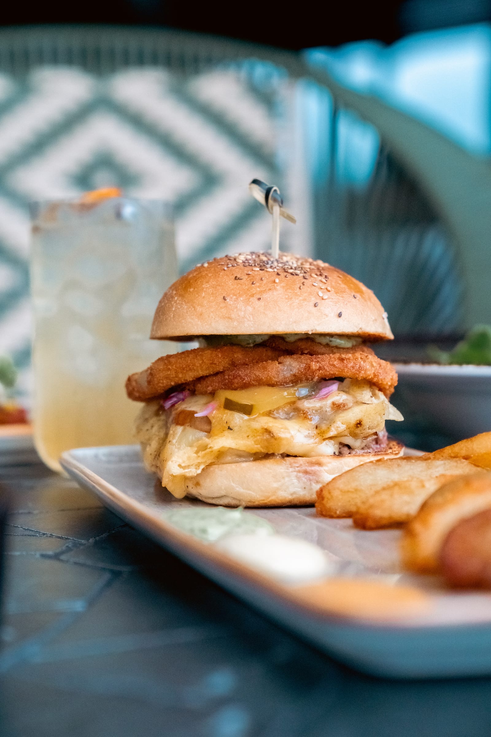 Hamburguesa de Icónico con papas a la francesa y un cóctel