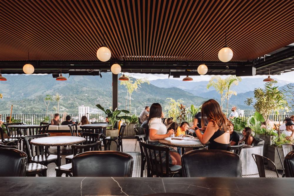 Clientes compartiendo en la terraza de Icónico con vista a la montaña
